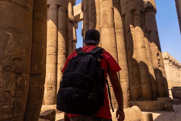 Person exploring ancient Egyptian temple columns.