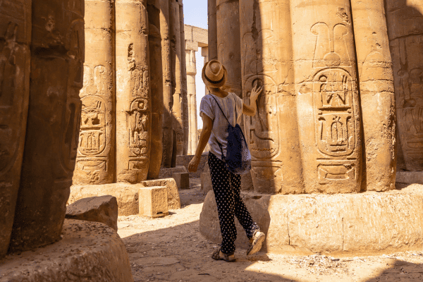 Person exploring ancient Egyptian temple columns