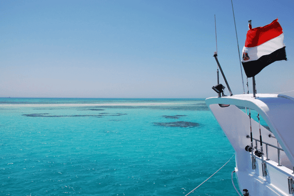 Boat on clear turquoise water with flag