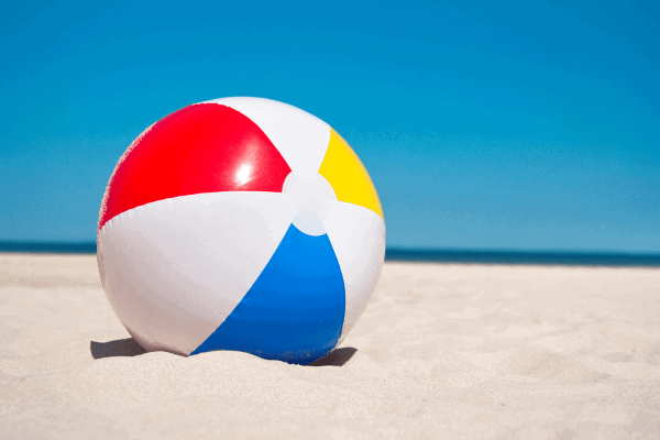 Colorful beach ball on sandy shore