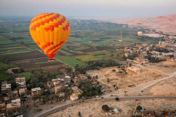 Colorful hot air balloon over green fields