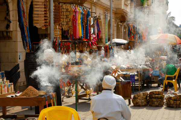Vibrant marketplace with smoke and colorful goods.