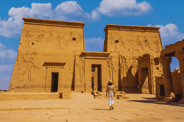 Person exploring ancient Egyptian temple ruins.