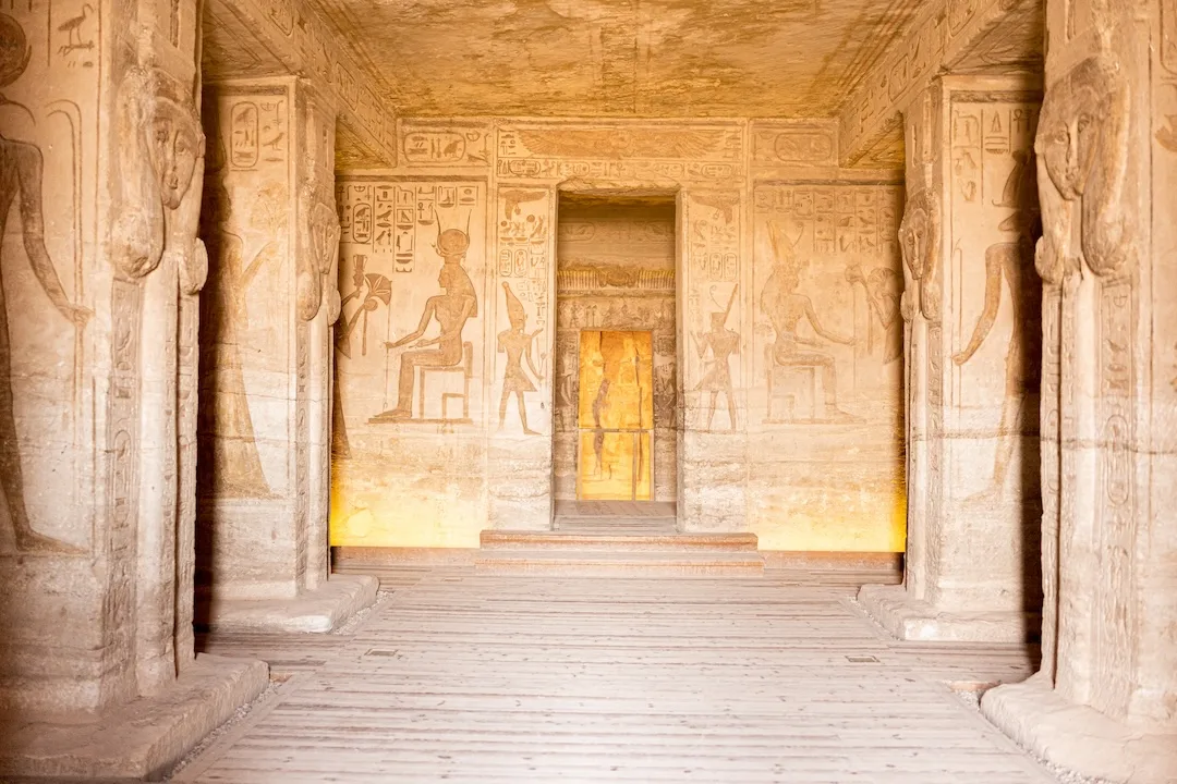 Ancient temple interior with hieroglyphs and pillars.