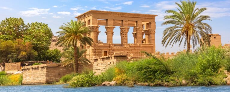 Ancient stone temple surrounded by greenery and water.