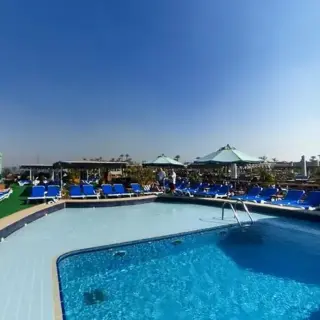 Outdoor poolside scene with lounge chairs and umbrellas.