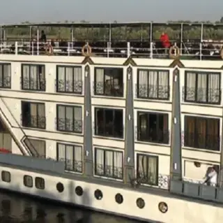 Luxury river cruise ship on tranquil waters.